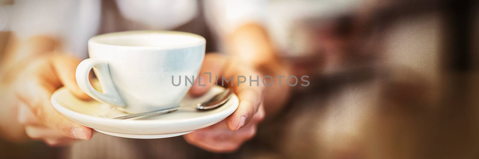 Close-up of male barista serving coffee at cafeteria