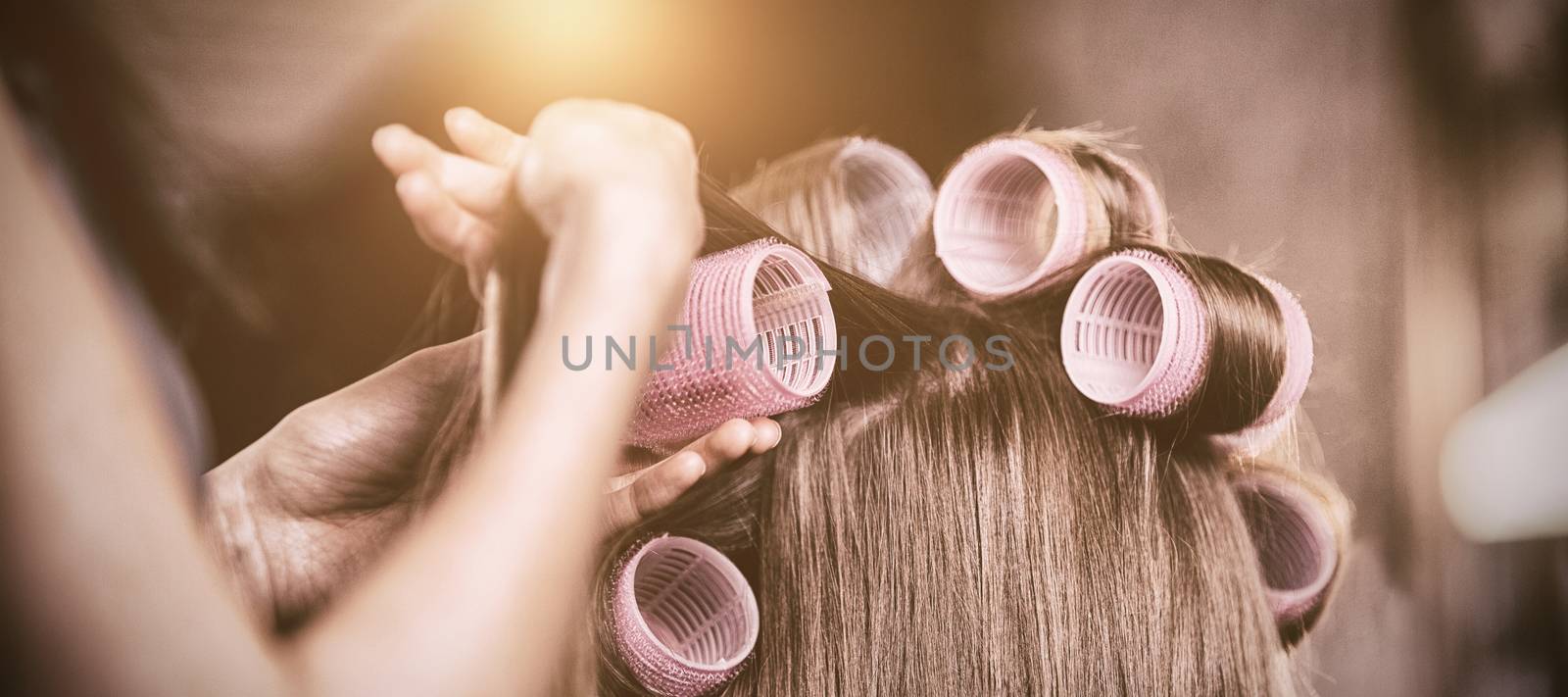 Female hairdresser styling customers hair at a salon