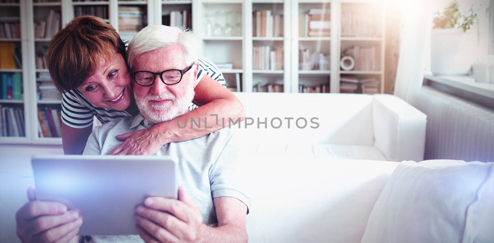 Senior couple using digital tablet in living room