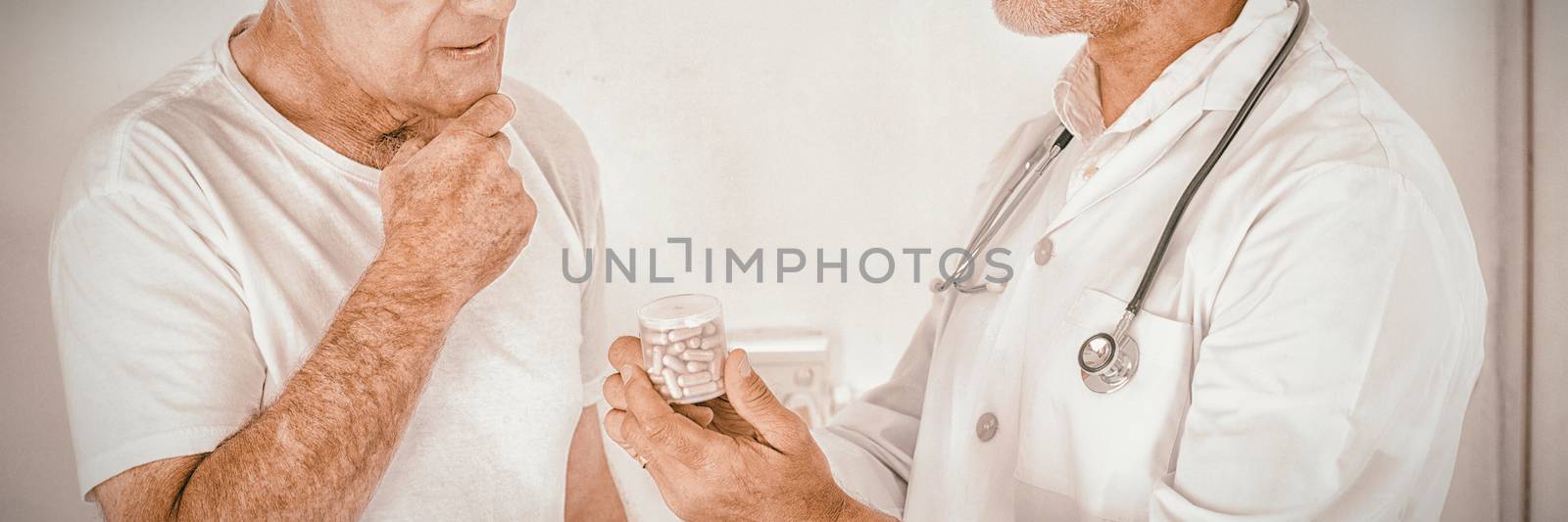 Male doctor advising senior man on medical prescriptions in hospital