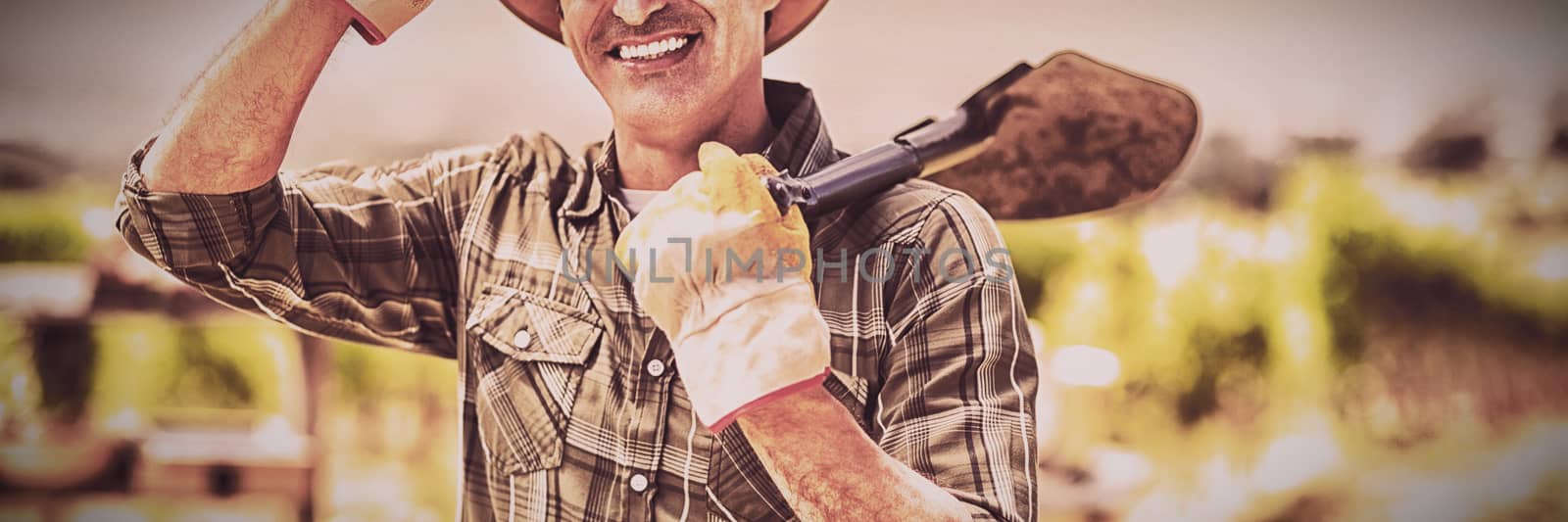 Portrait of farmer carrying shovel on a sunny day
