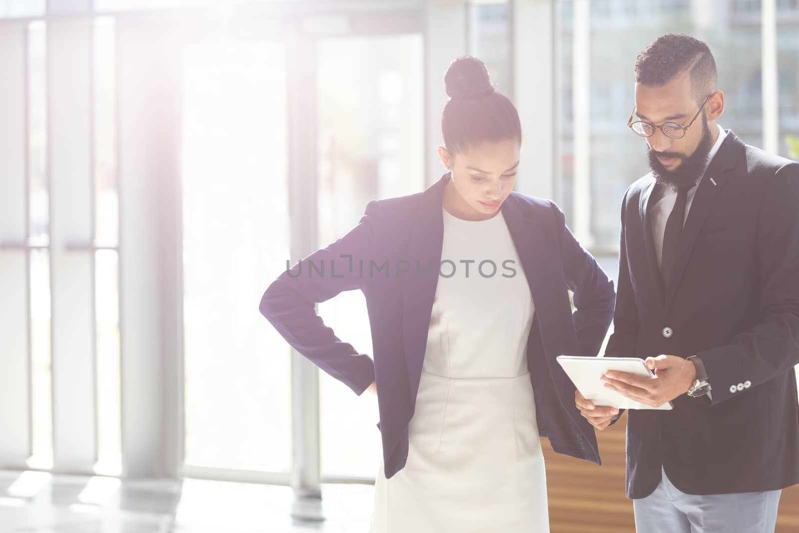 Business people looking and  discussing over digital tablet in office by Wavebreakmedia