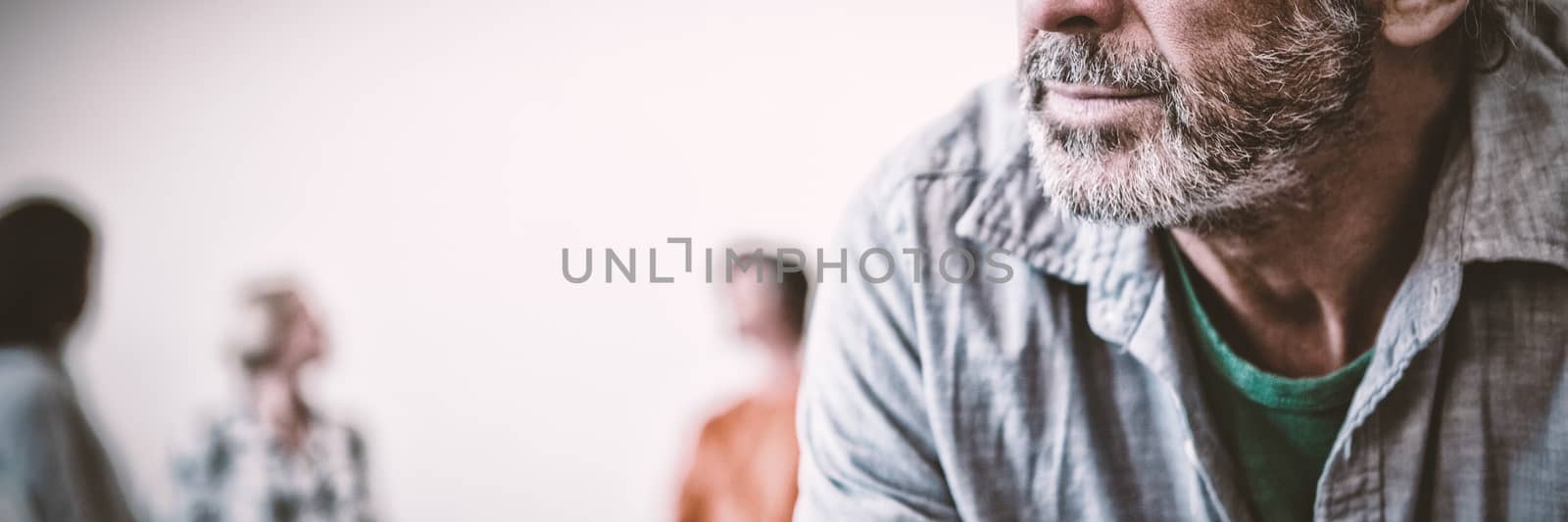 Tensed man with friends discussing in background at art class, Close-up