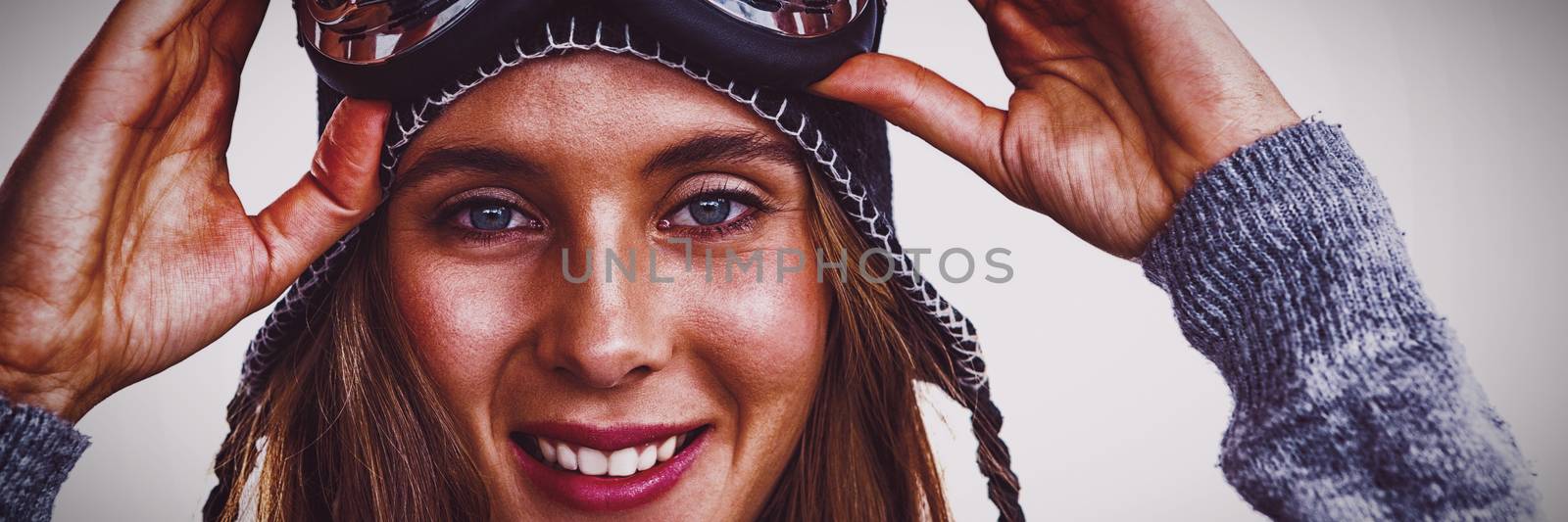 Portrait of woman with ski goggles against white background