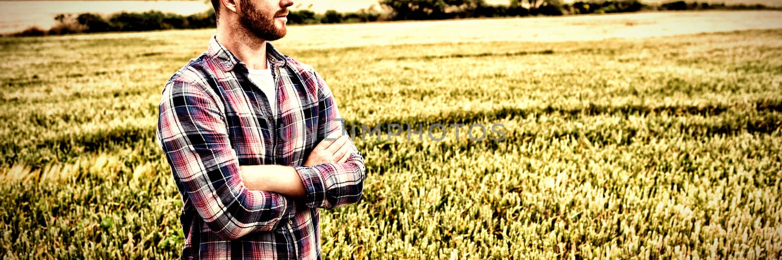 Farmer standing with arms crossed while looking away by Wavebreakmedia