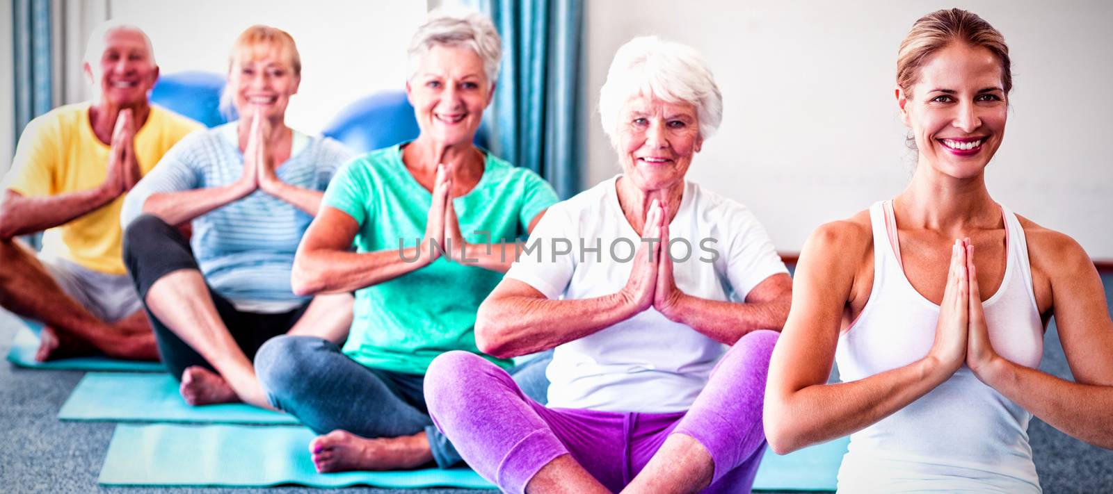 Instructor performing yoga with seniors during yoga class
