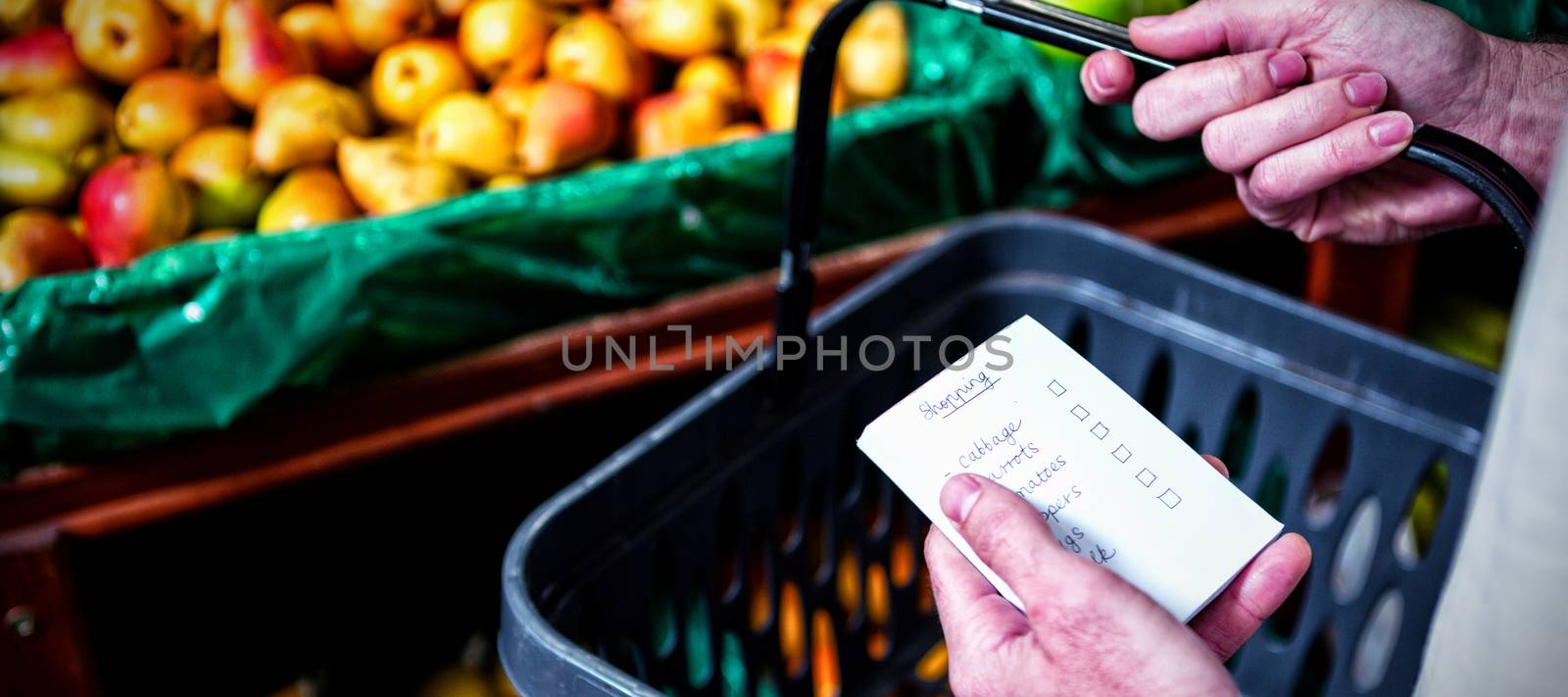 Man holding shopping basket and checklist in supermarket