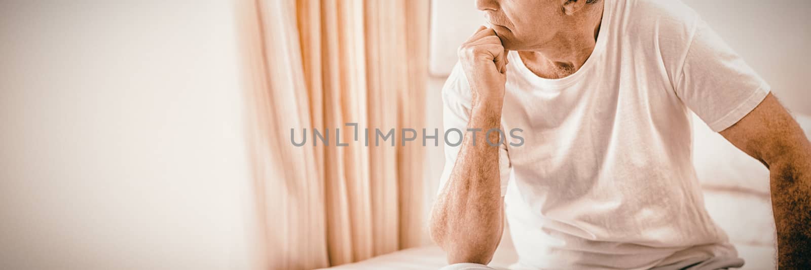 Worried senior man sitting on bed by Wavebreakmedia