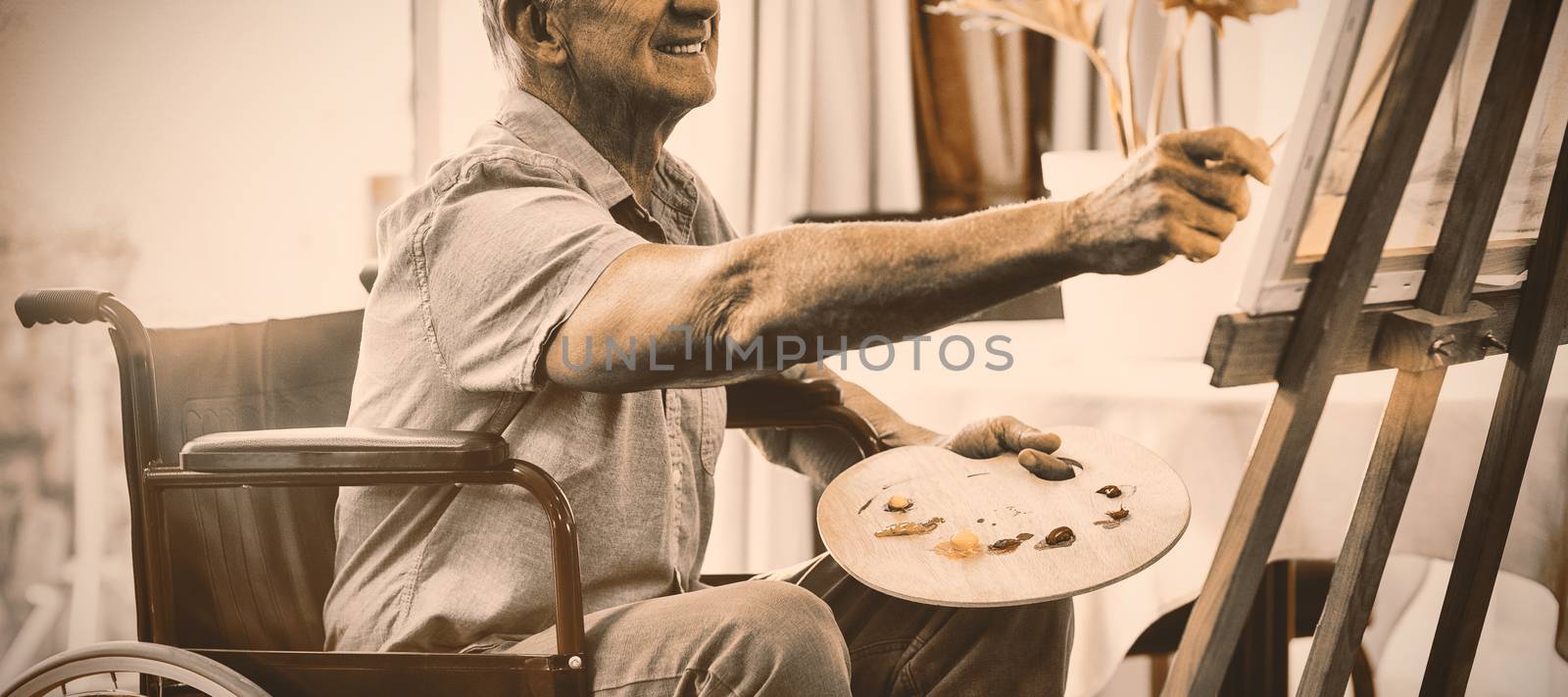 Happy senior man painting at home