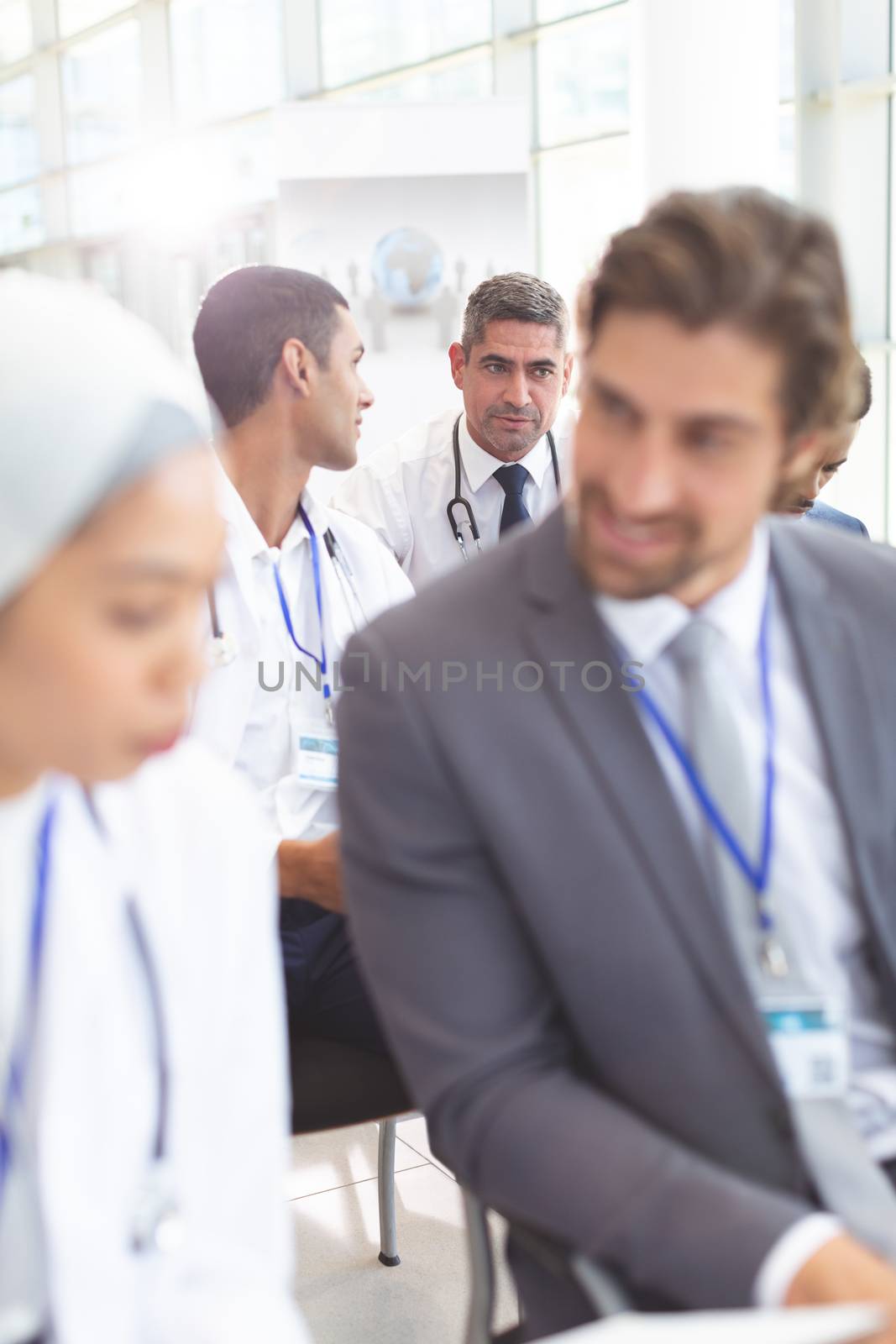 Male doctors interacting with each other during seminar by Wavebreakmedia
