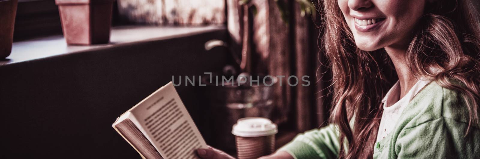 Attractive girl posing with book at coffee shop