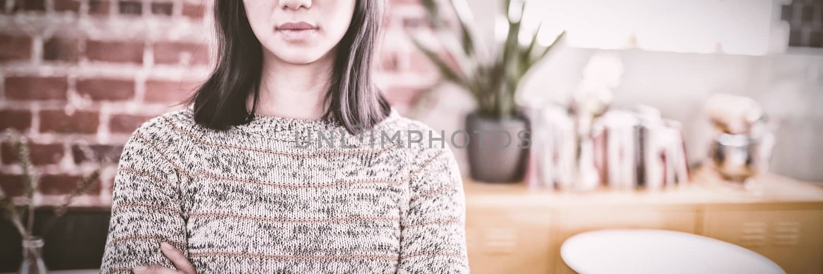 Portrait of confident beautiful young woman standing with arms crossed by Wavebreakmedia