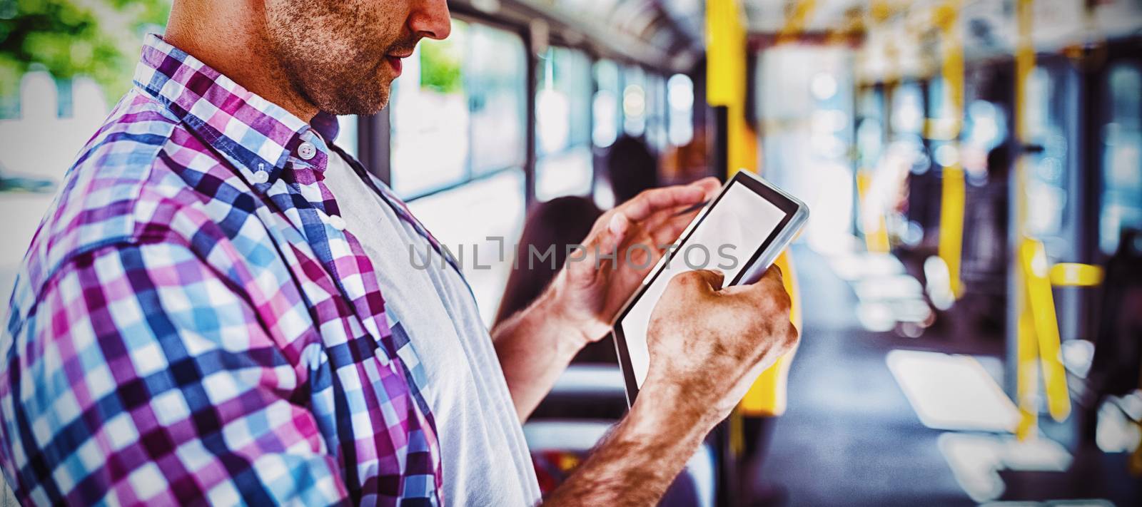 Handsome man using digital tablet while travelling in bus
