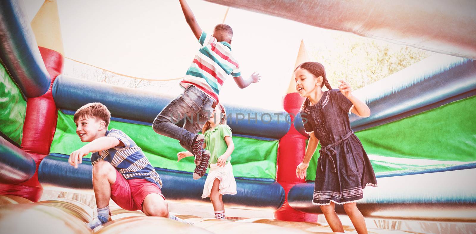 Friends jumping on bouncy castle by Wavebreakmedia