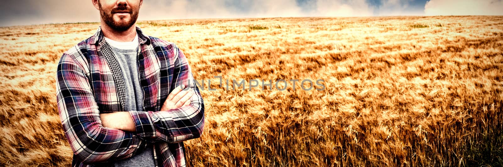 Portrait of farmer standing with arms crossed in the field on a sunny day