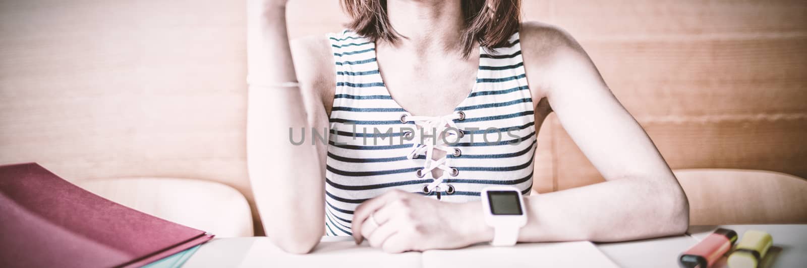 Young woman raising hand in classroom at college