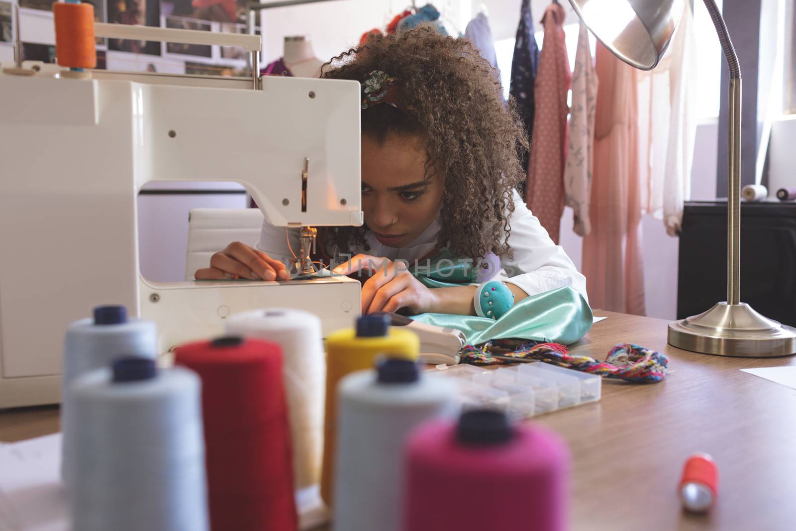 Front view of female fashion designer working with sewing machine