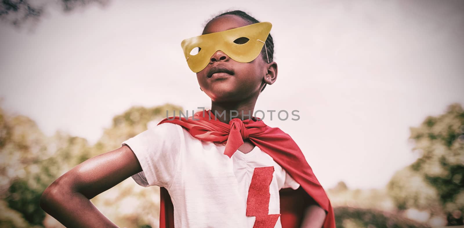 Cute girl pretending to be superhero with hands on hip by Wavebreakmedia