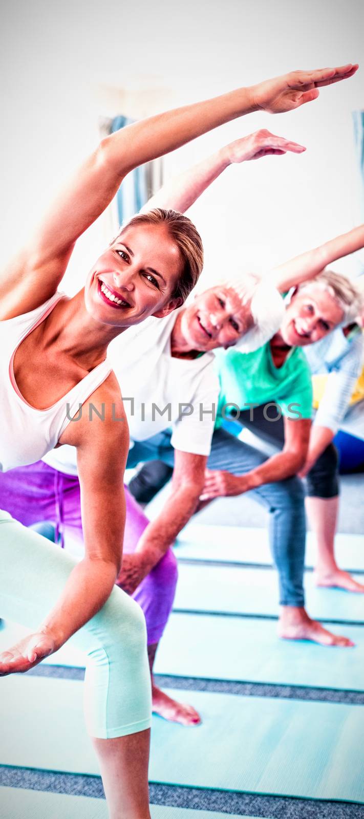 Portrait of instructor performing yoga with seniors during sports class