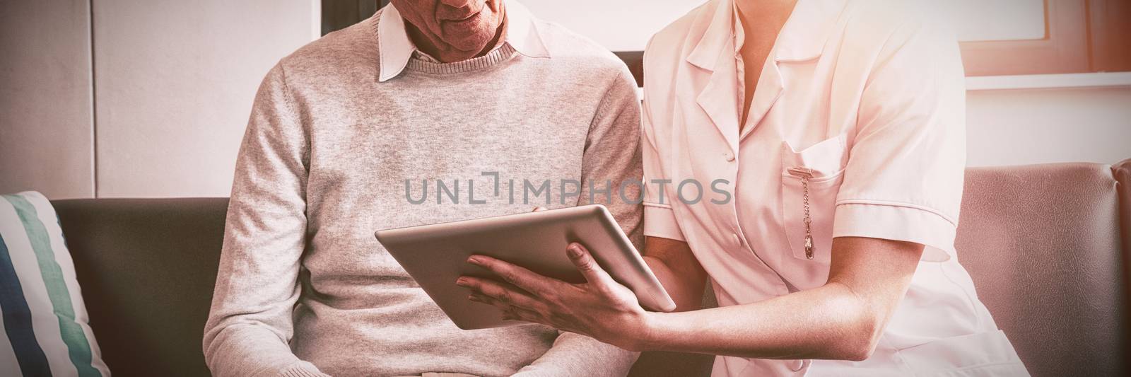 Nurse and senior man using a digital tablet in a retirement home