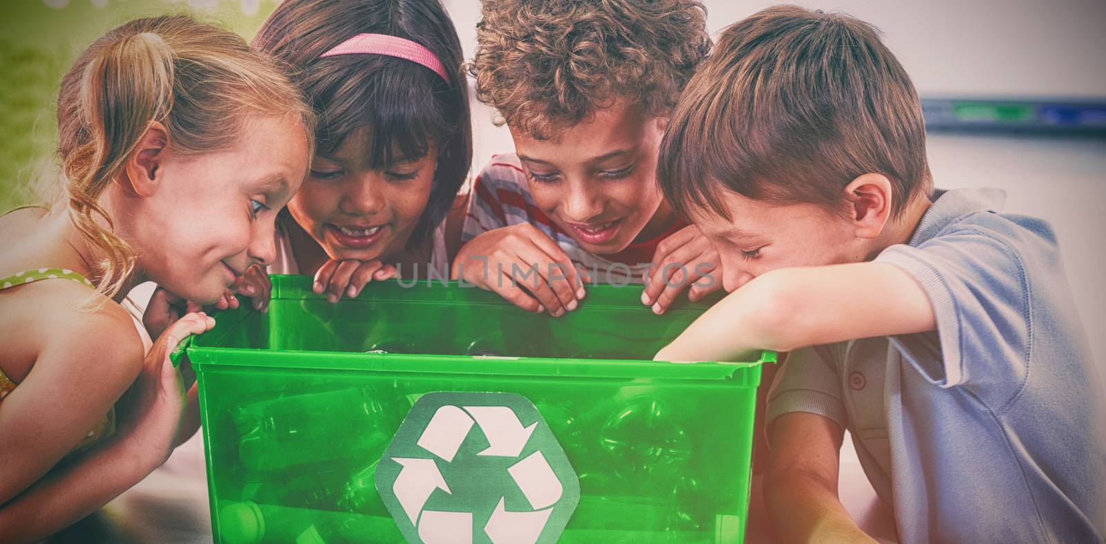 Children looking at bottles in recycling box at classroom 
