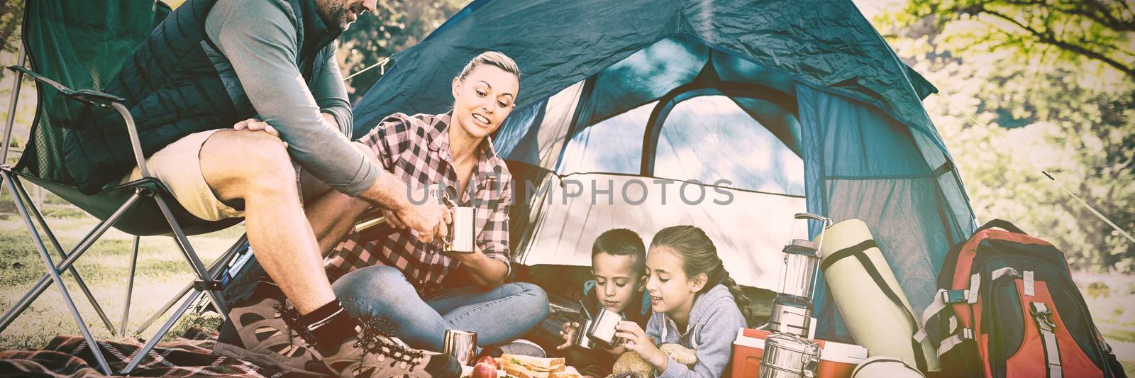 Family having snacks and coffee outside the tent by Wavebreakmedia