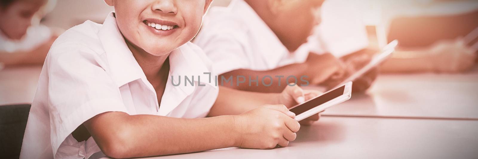 School kids using mobile phone in classroom by Wavebreakmedia