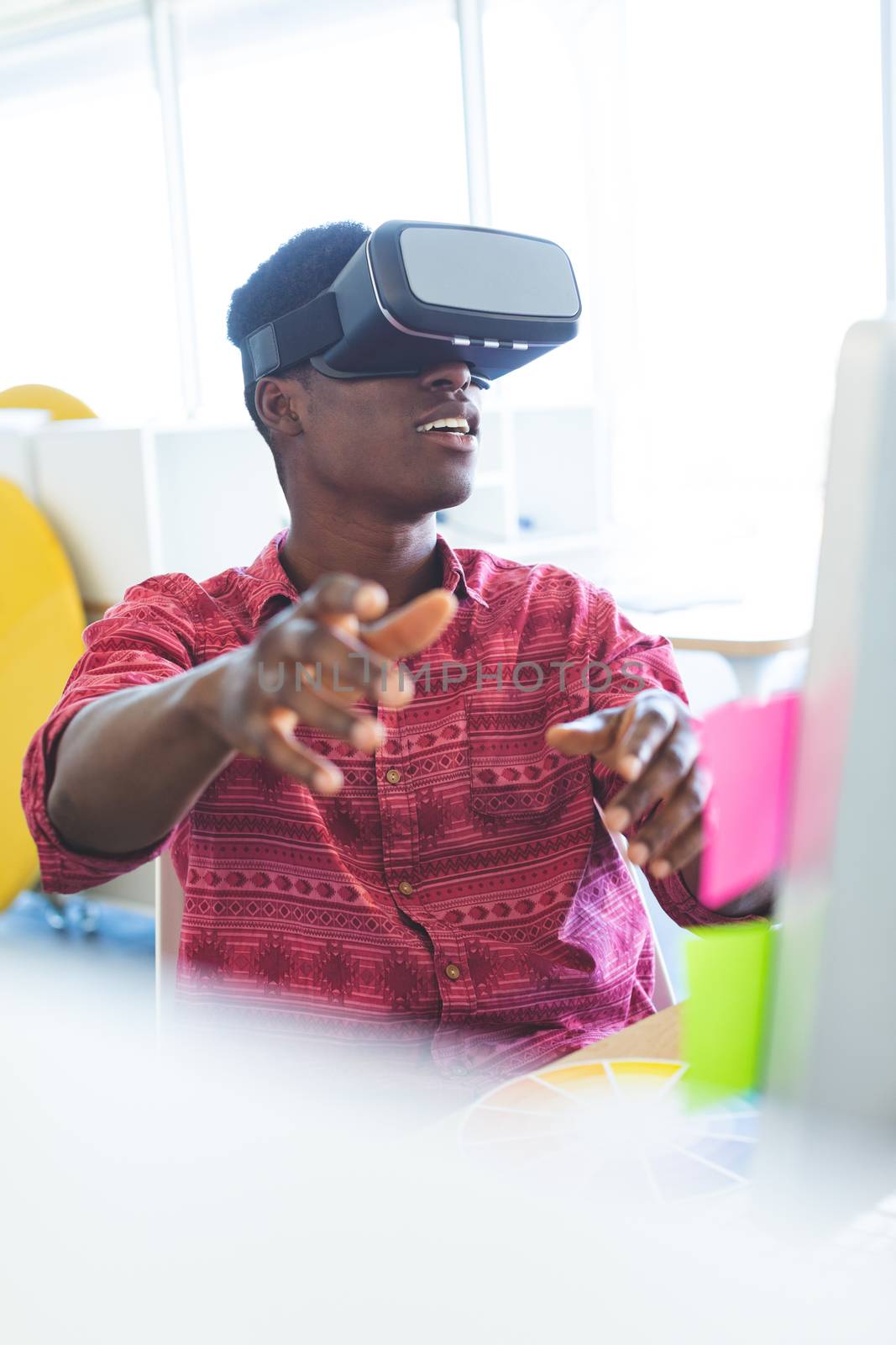 Front view of graphic designer using virtual reality headset in office 