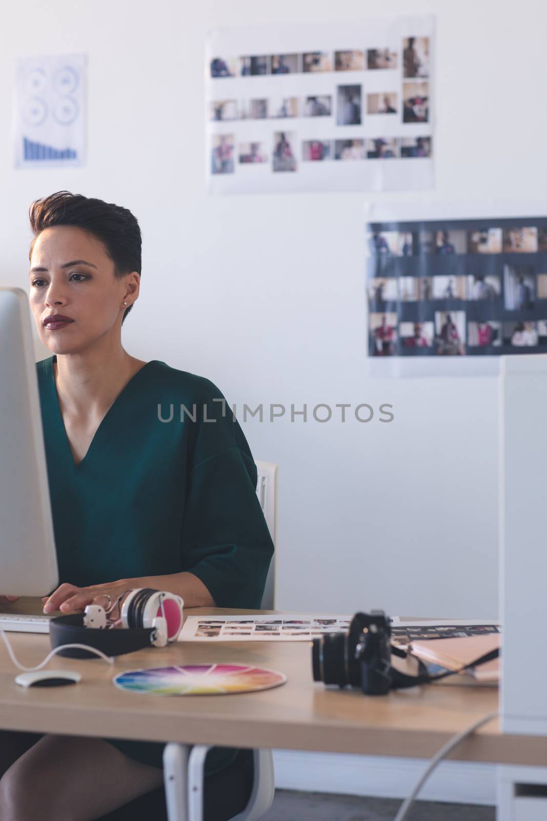 Female graphic designer working on computer at desk in the office