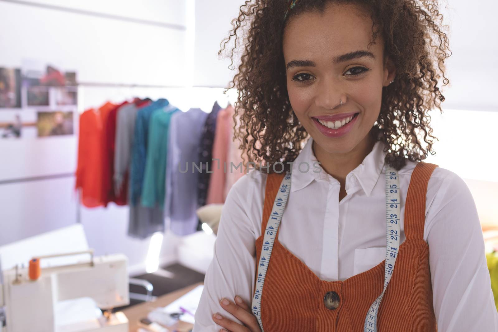 Portrait of female fashion designer standing at table in design studio