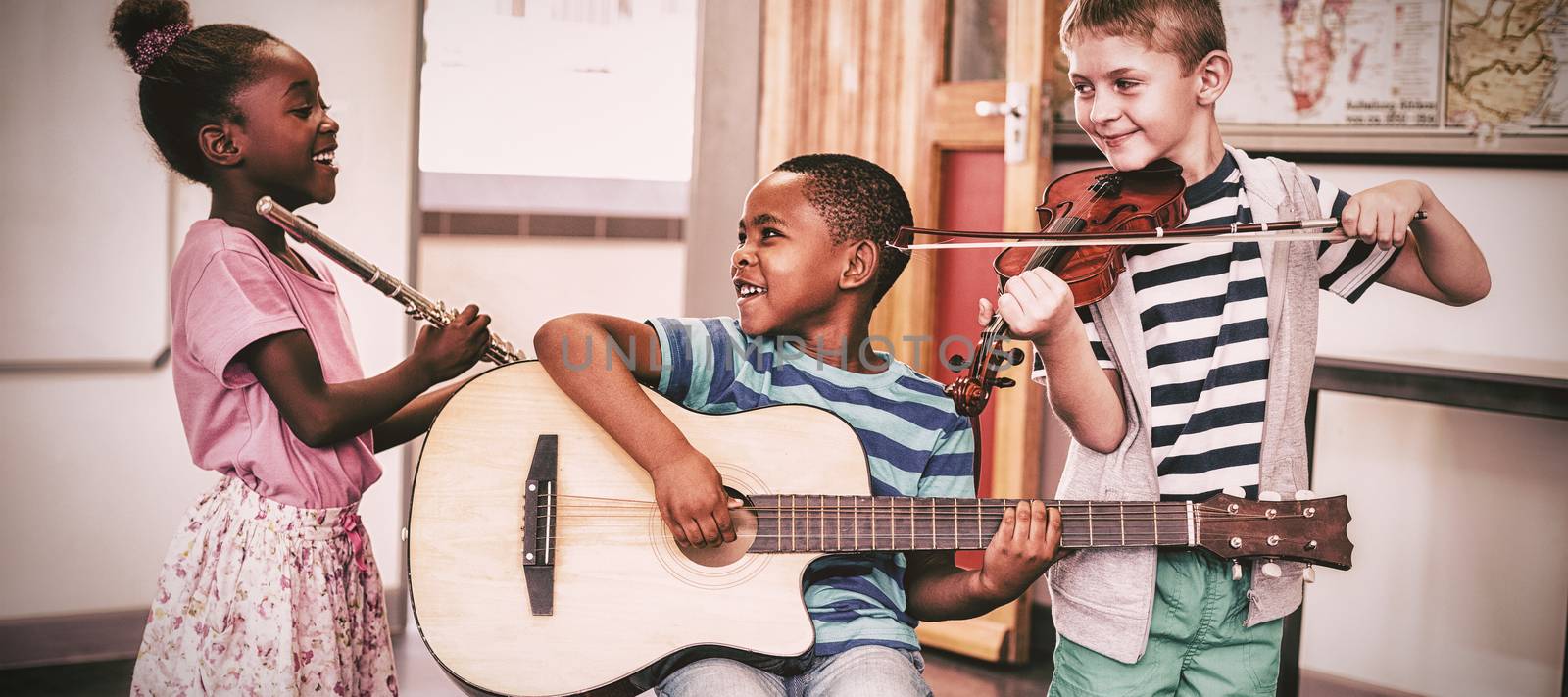 Children playing musical instruments in classroom by Wavebreakmedia