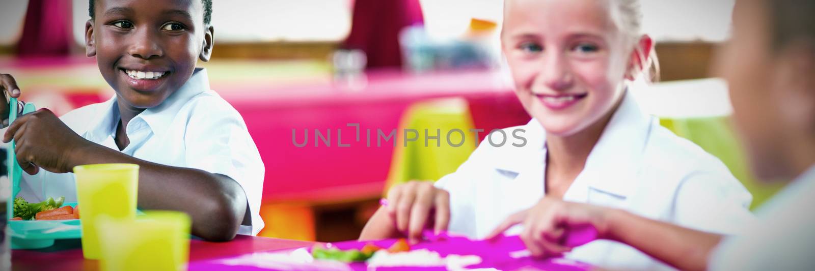 Children having lunch during break time in school cafeteria by Wavebreakmedia