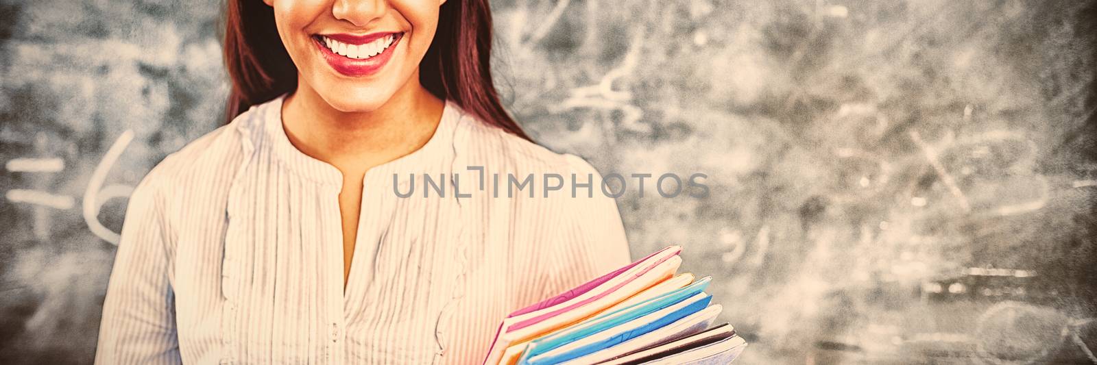 Teacher standing against blackboard by Wavebreakmedia