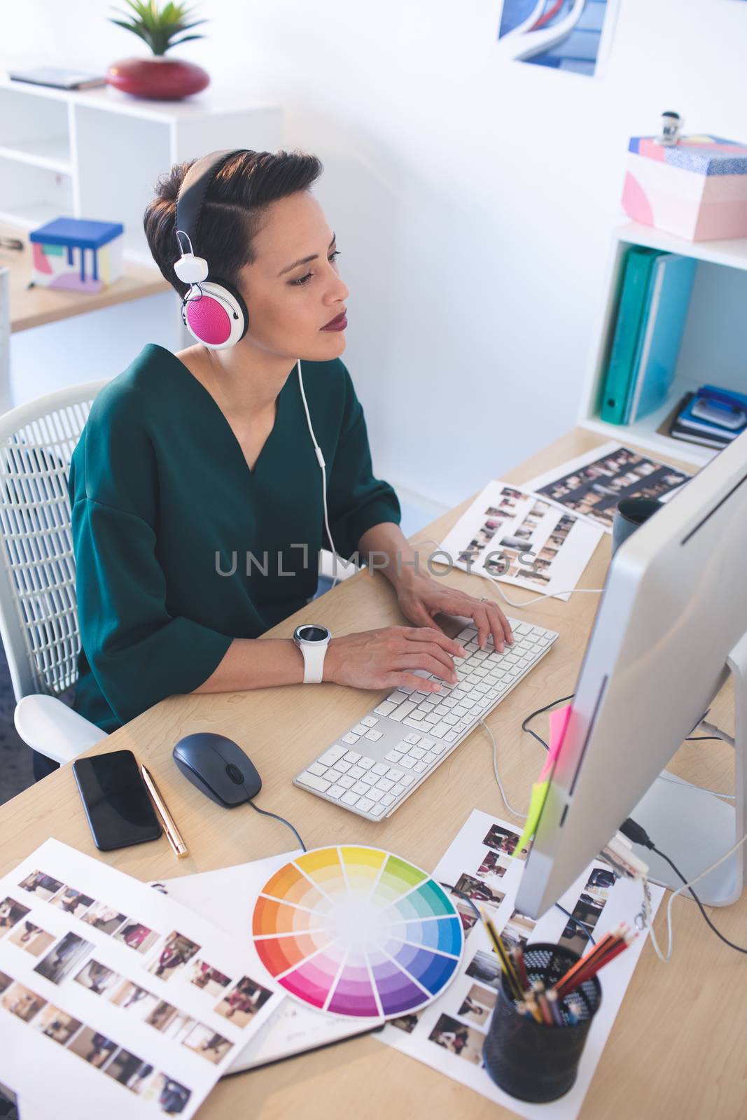 Female graphic designer working on computer at desk in the office