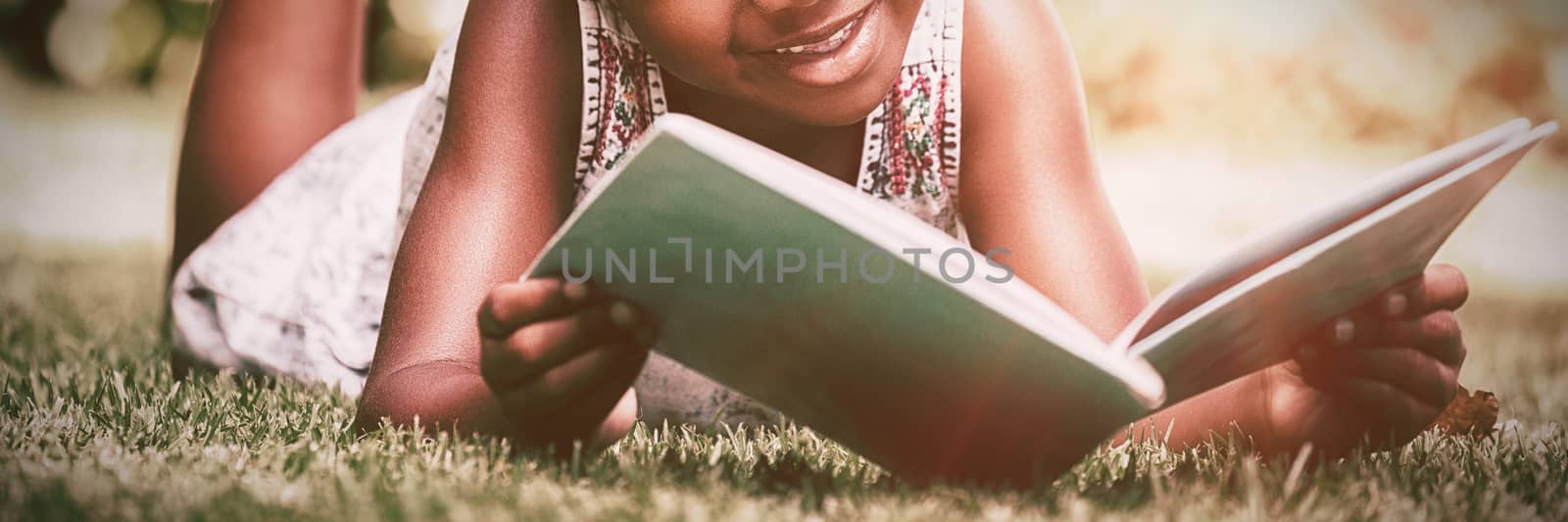 Little girl reading a book at park by Wavebreakmedia