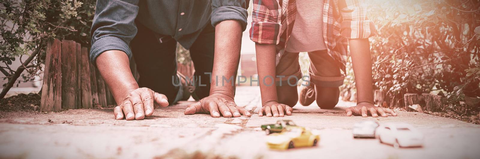 Grandson and grandfather playing with toy cars by Wavebreakmedia