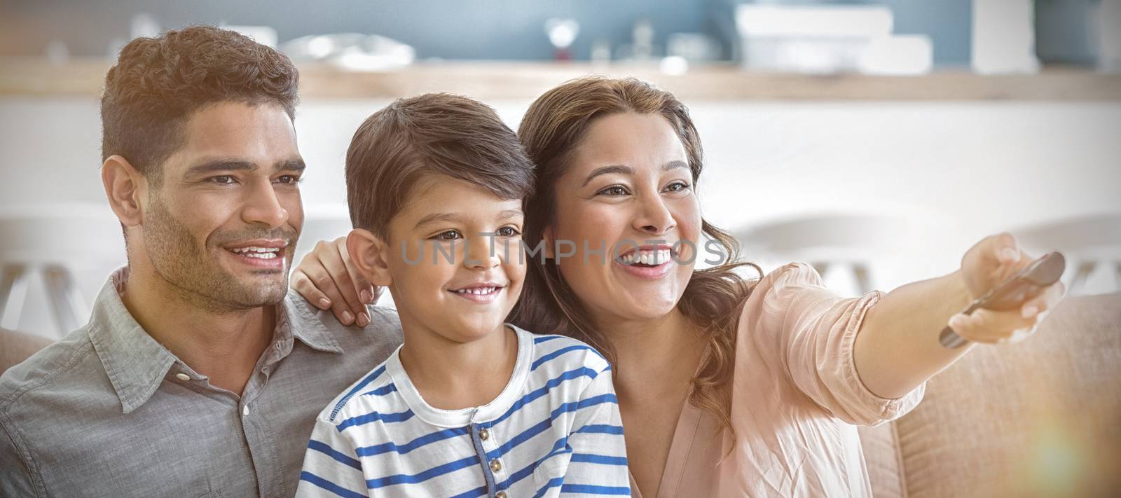 Parents and son watching television in living room at home