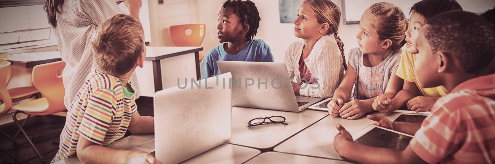 Teacher showing new technology to students by Wavebreakmedia