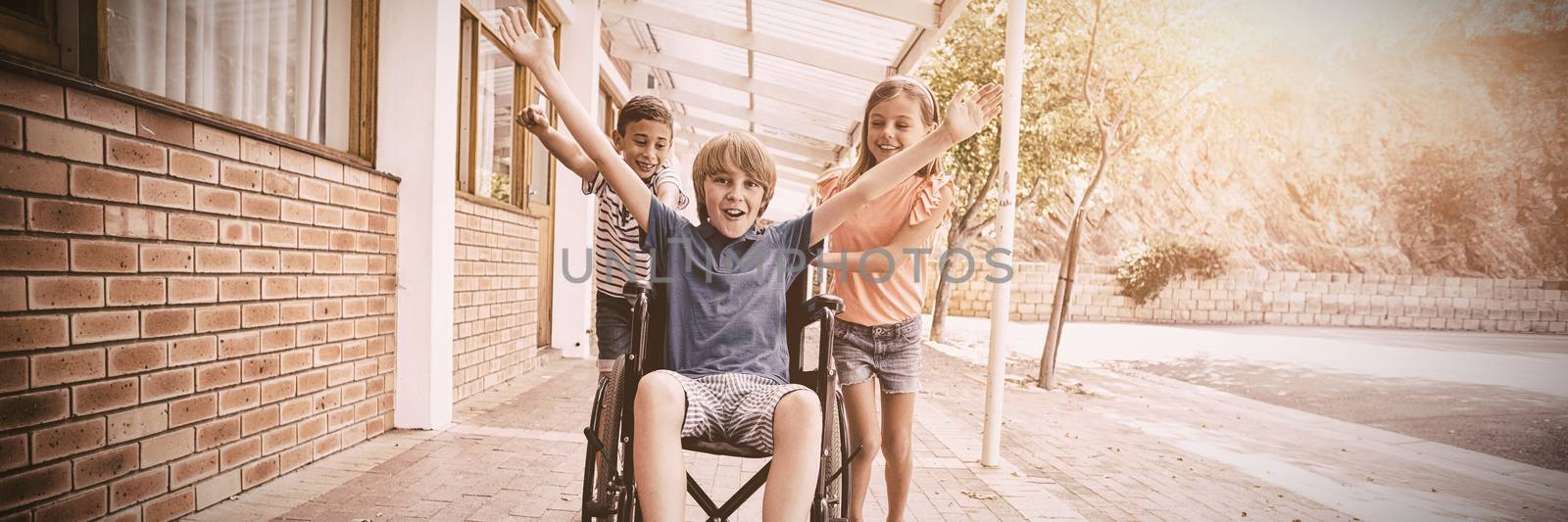 School kids pushing a boy on wheelchair by Wavebreakmedia