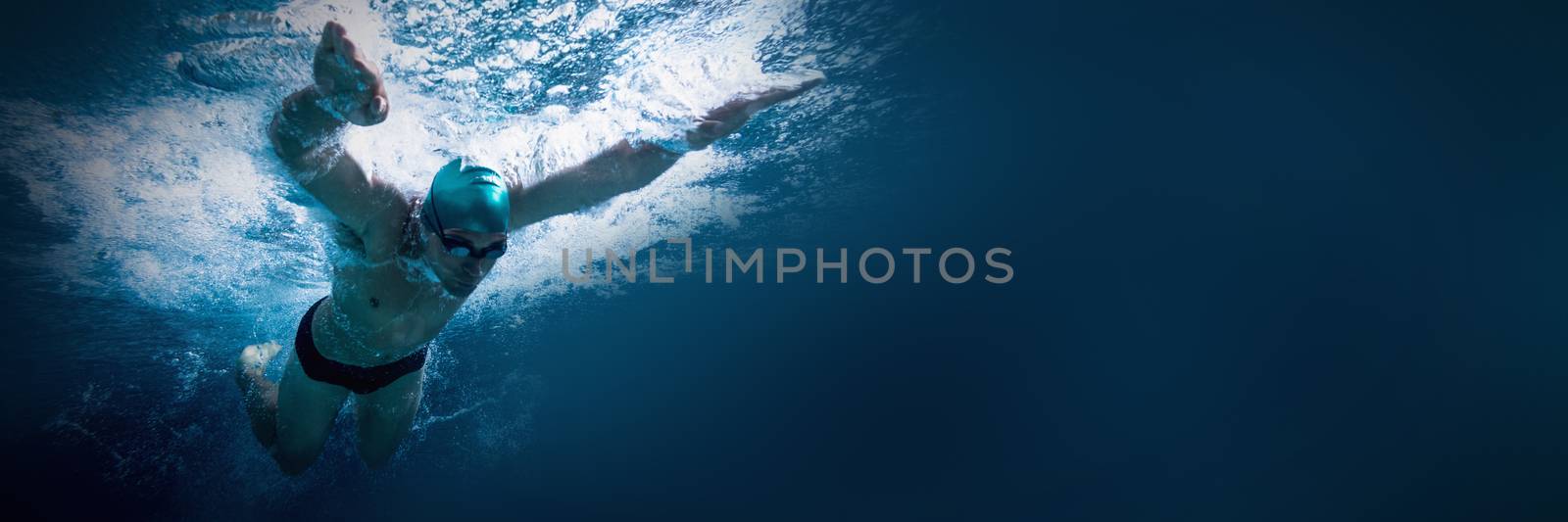 Fit swimmer training by himself in the swimming pool at the leisure centre