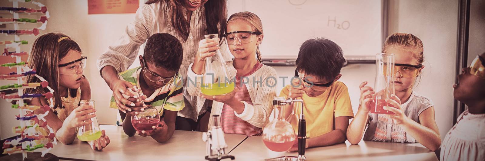 Pupils learning science with teacher in classroom