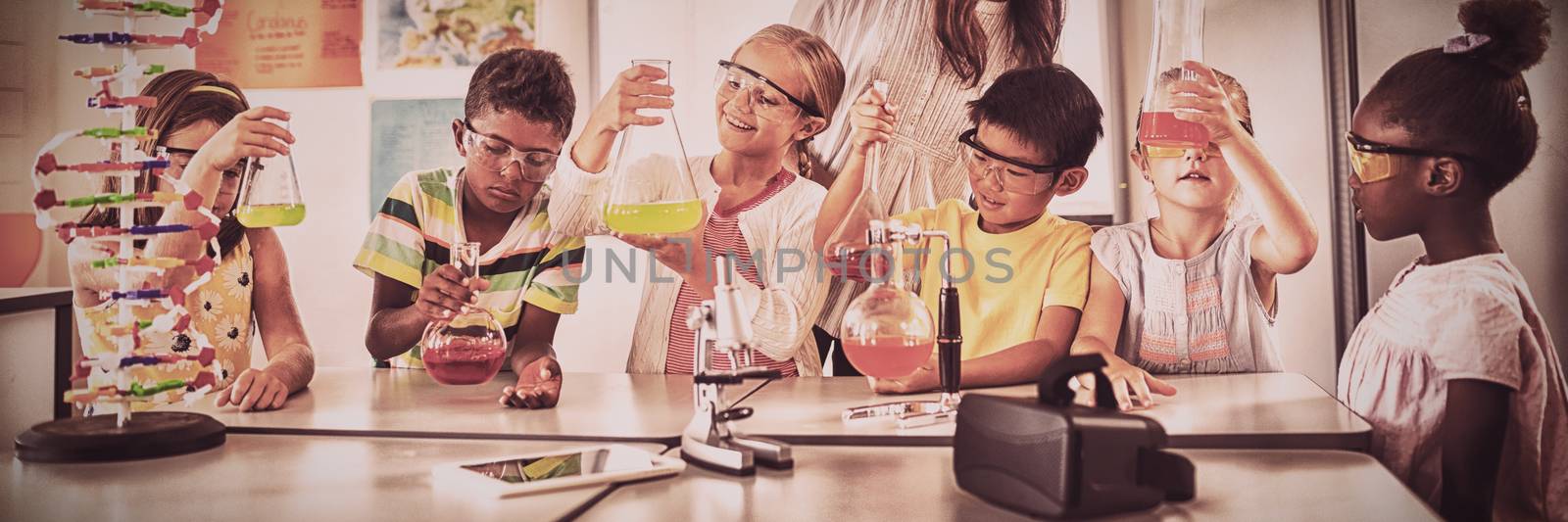 Smiling children doing science project in classroom