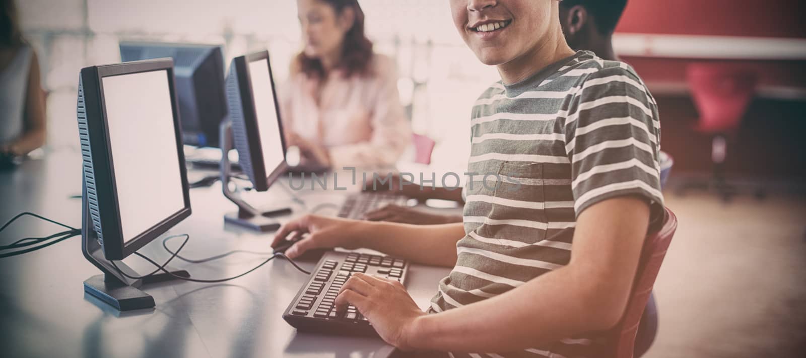 Student using computer in classroom by Wavebreakmedia