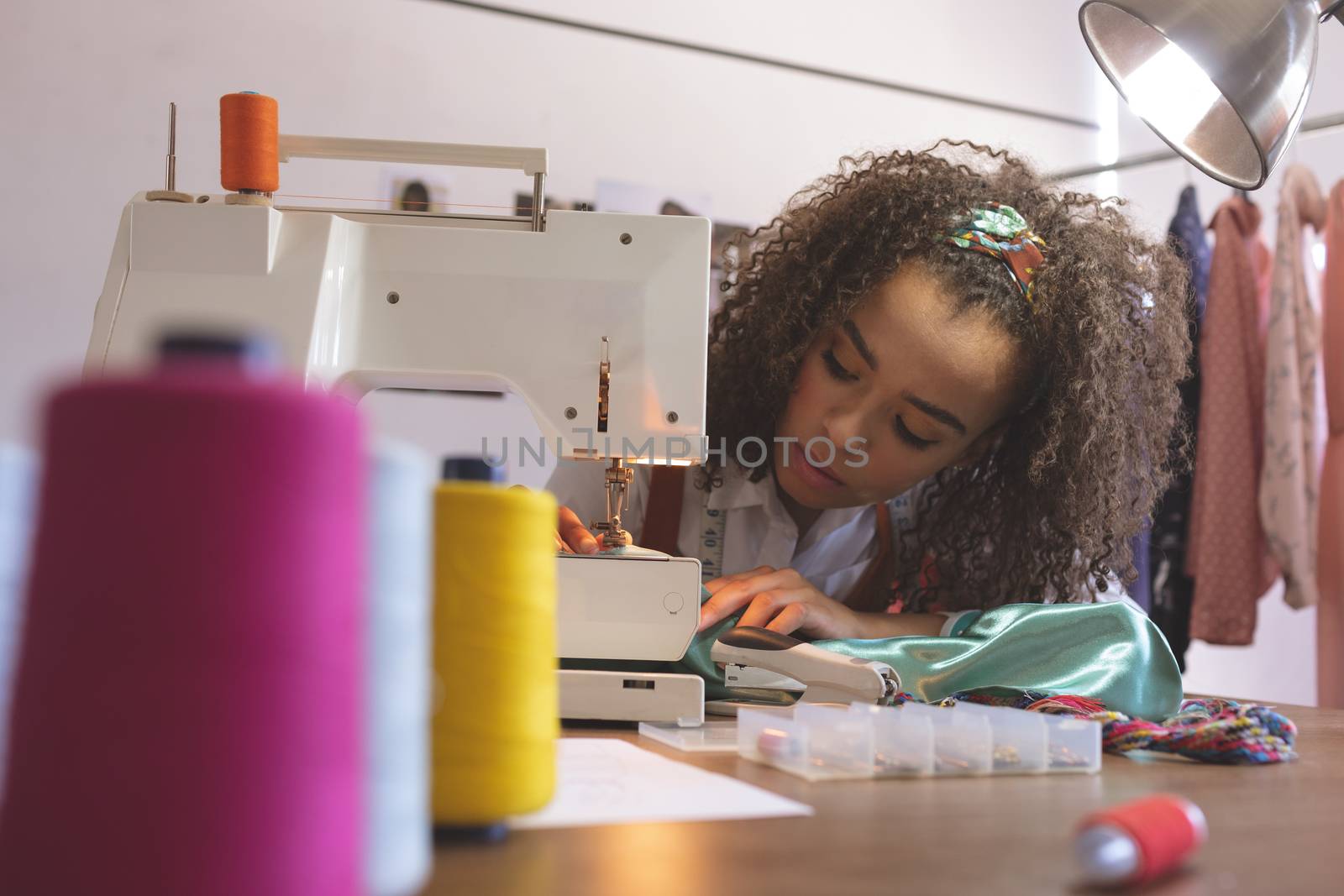 Front view of female fashion designer working with sewing machine