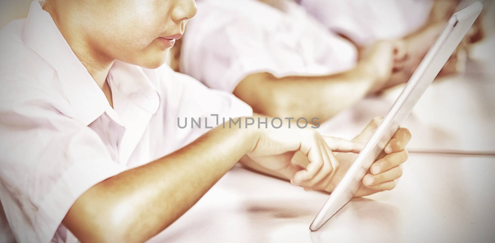 Kids using digital tablet in classroom at school