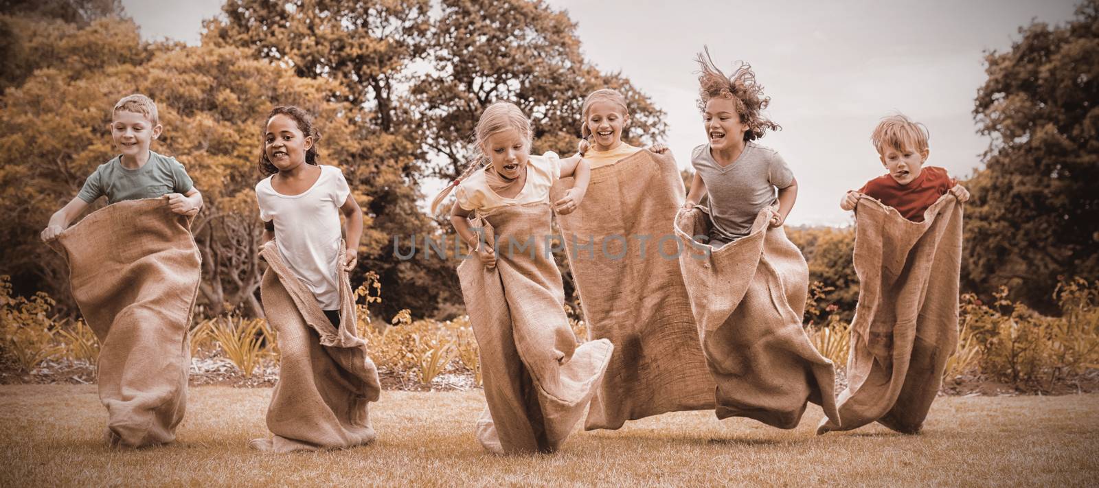 Children having a sack race in park by Wavebreakmedia