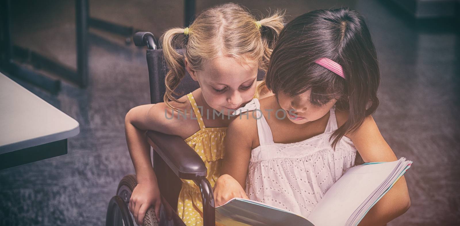 Girls reading in the classroom by Wavebreakmedia