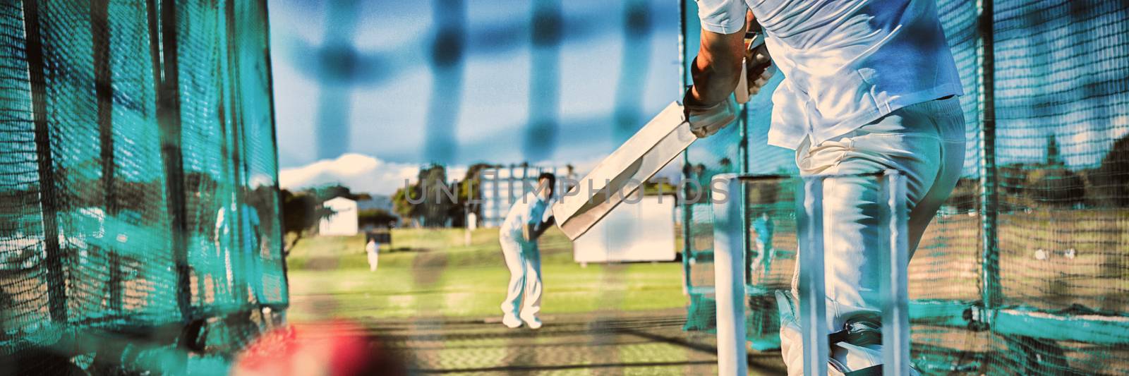 Low section of sportsman playing cricket at field by Wavebreakmedia