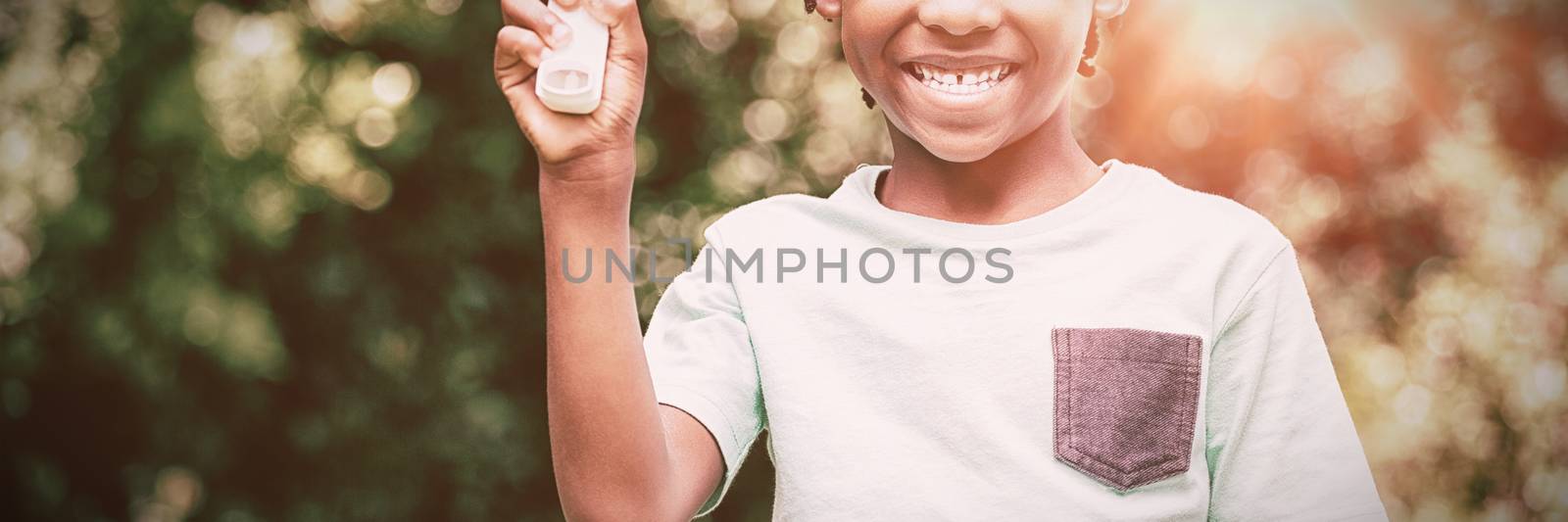 Boy showing his asthma inhaler in the park