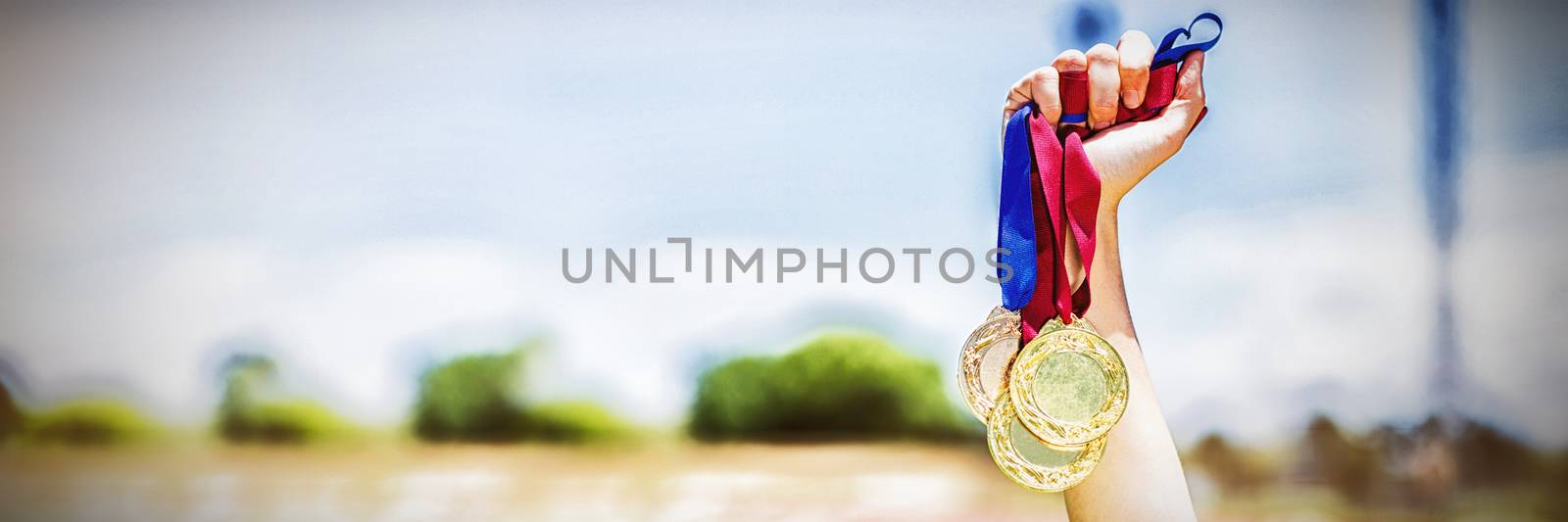 Hand of female athlete holding gold medals by Wavebreakmedia